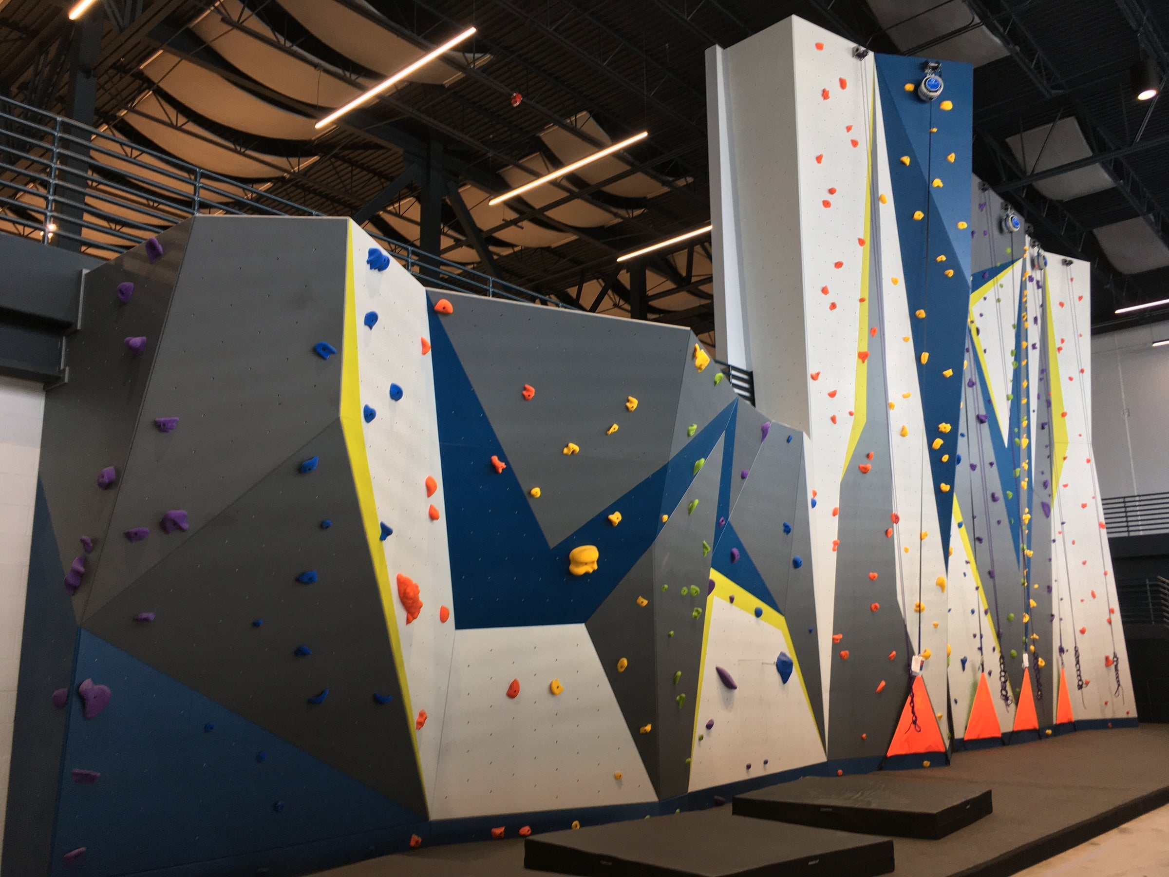 A sport climbing wall in a recreation center with bouldering and lead climbing sections
