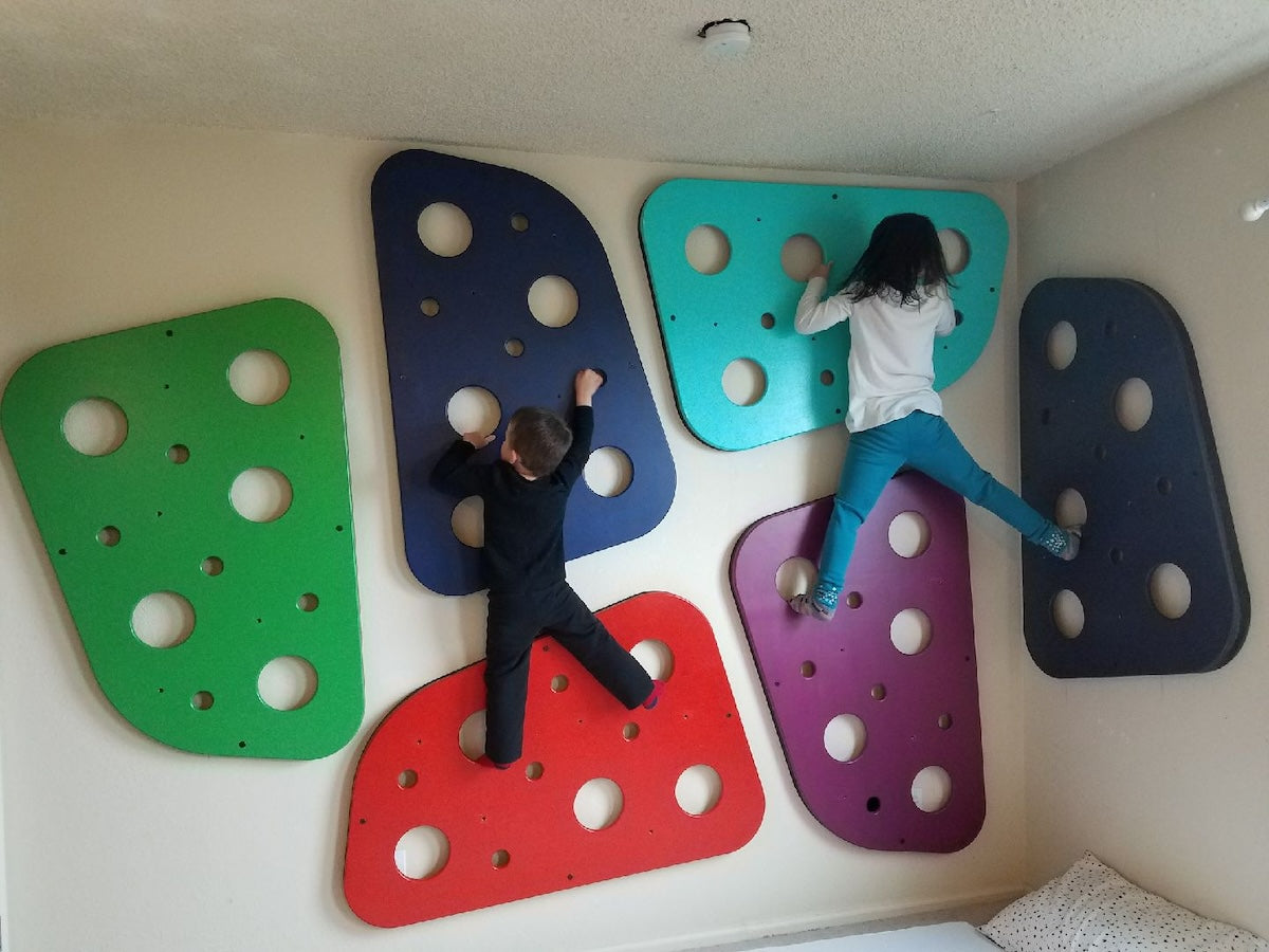 Two kids on climbing panels in their home