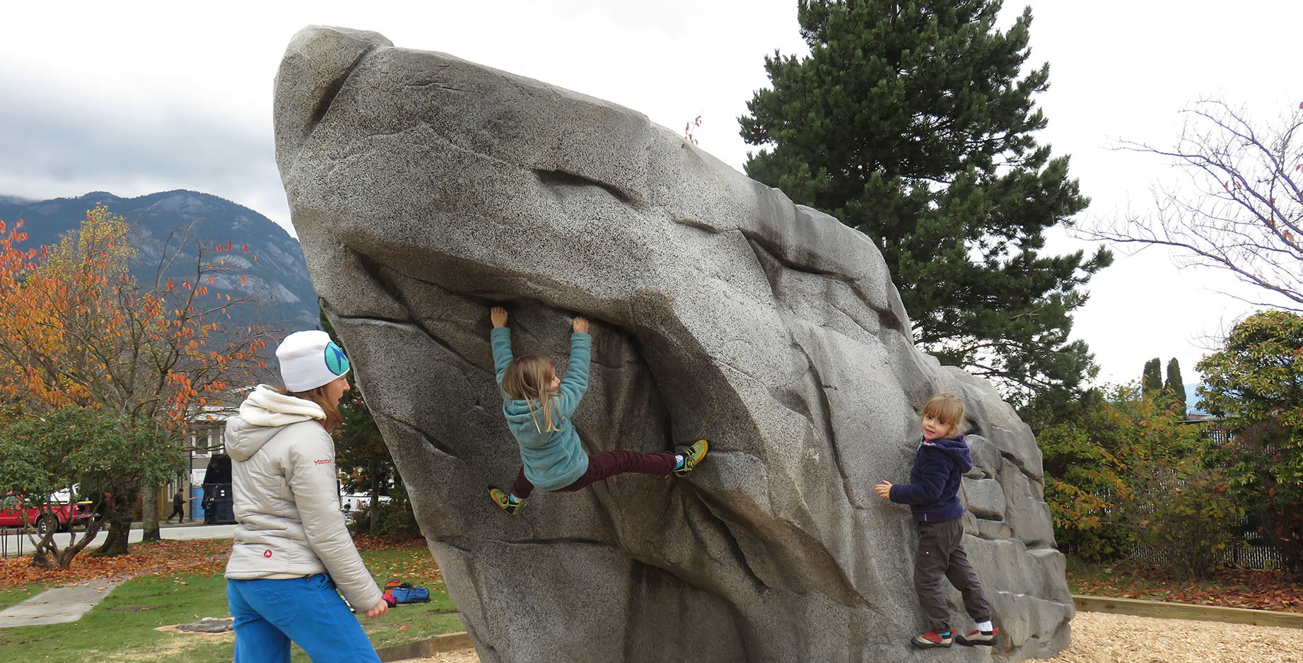 Kids learn bouldering, a type of sport climbing, in a city park in Squamish, BC